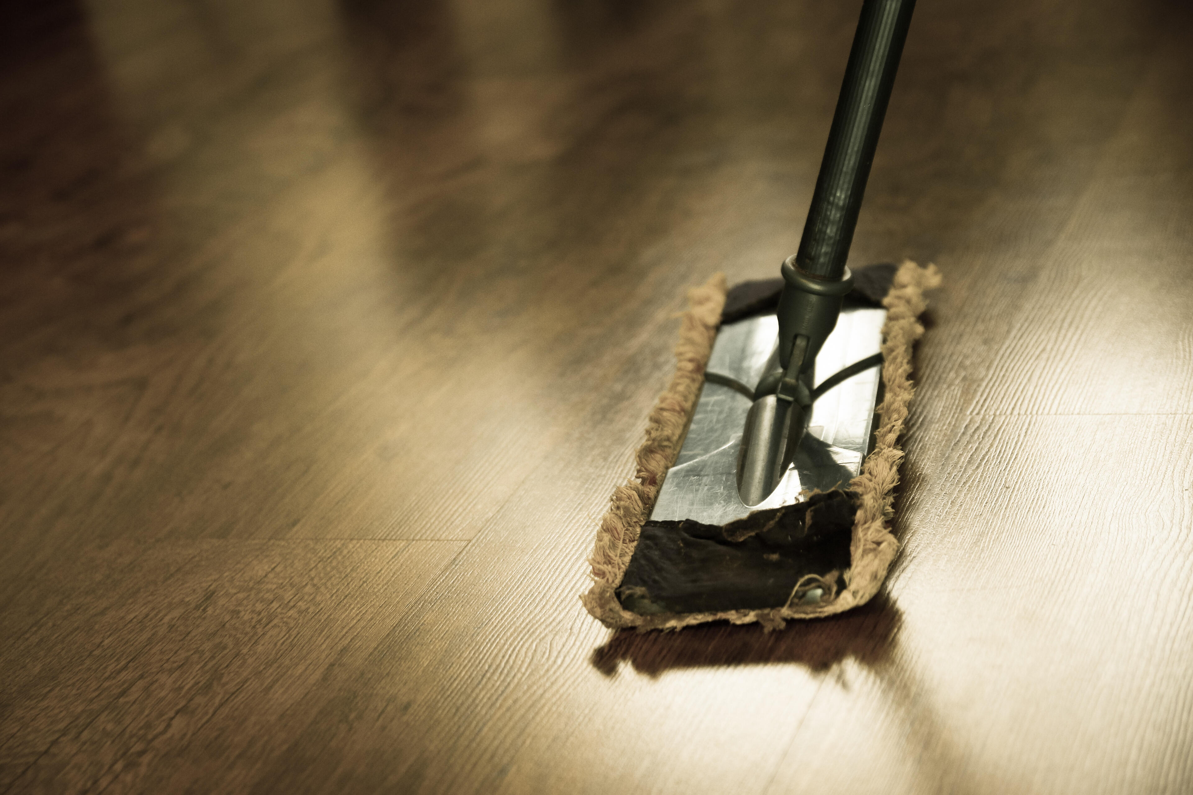 Commercial Office Cleaning Professional cleaner mopping a hardwood floor in a commercial office space.